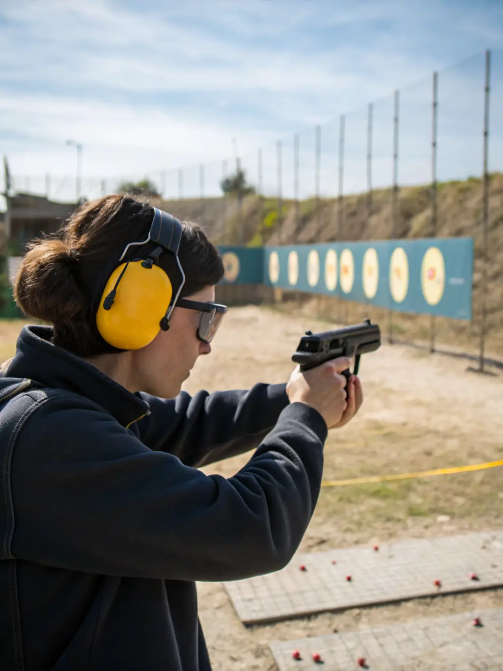 A close-up of a shooter carefully aiming at a clay target during a ball-trap competition, showcasing focus and precision.